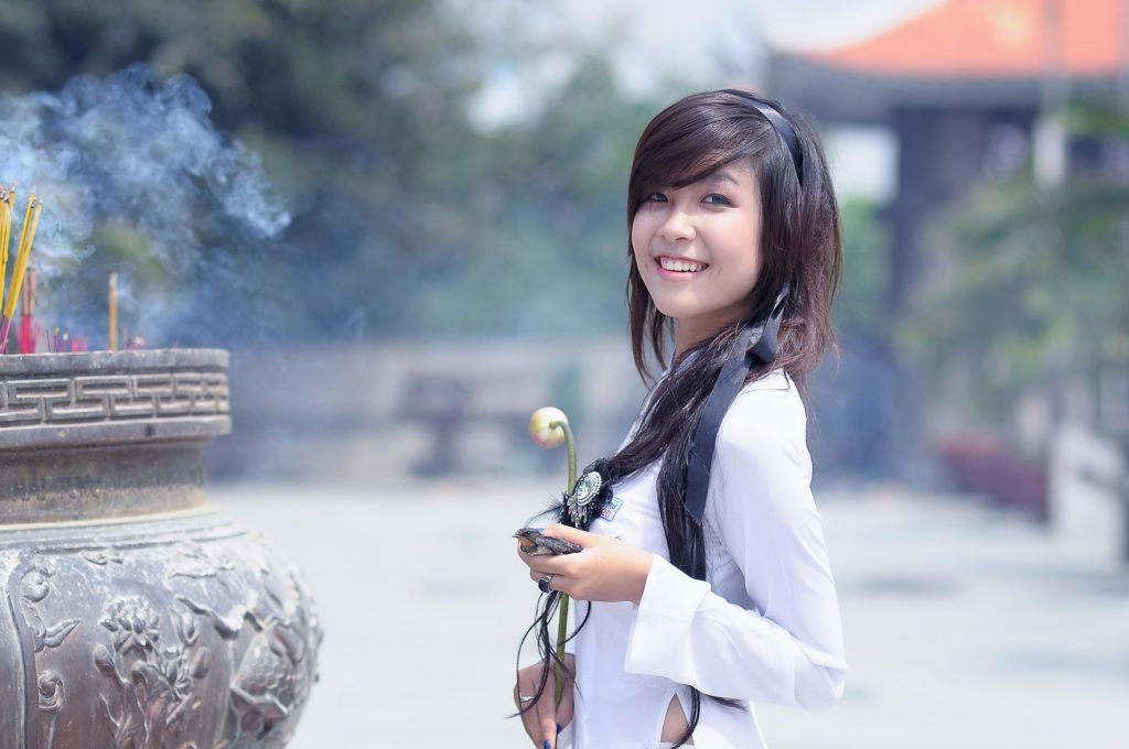 Asian American woman holding a flower