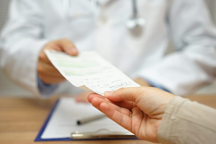 doctor handing prescription to patient