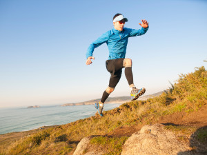 Man practicing trail running in a coastal landscape