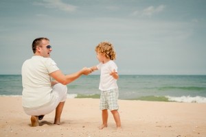 father and son playing at the beach in the day time