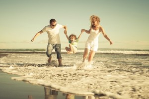 Happy family playing on the beach at the day time