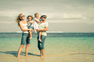 Happy family standing on the beach at the day time