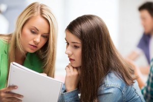 student girls looking at notebook at school