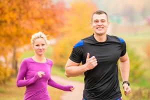 cheerful young athletes jogging autumn morning