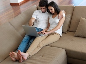 relaxed young couple working on laptop computer at home