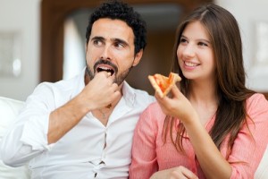 Couple eating pizza and watching TV