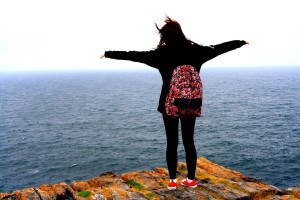 Woman standing on the beach with arms wide open showing freedom