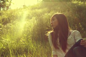 Woman in the grass experiencing Mindfulness