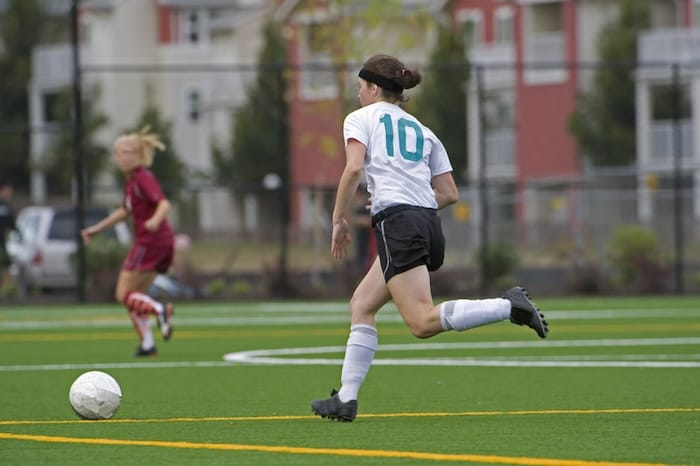 female soccer play driving the ball in a match