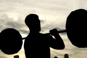 Man lifting weights while suffering from Compulsive Exercise