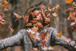 Woman throwing leaves to practice mindfulness in Dialectical Behavior Therapy Skills