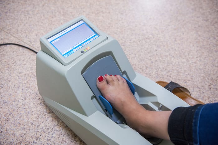 woman's foot on a device to check for osteoporosis