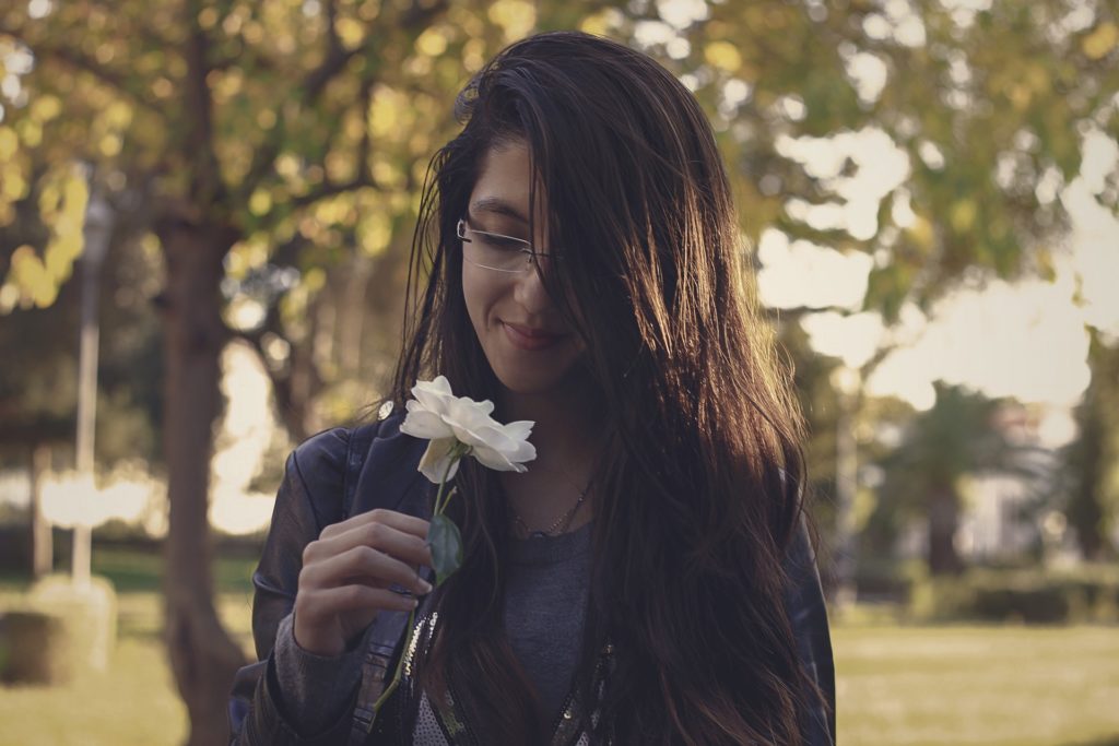 Woman smelling a flower and using Mindfulness in Eating Disorder Recovery