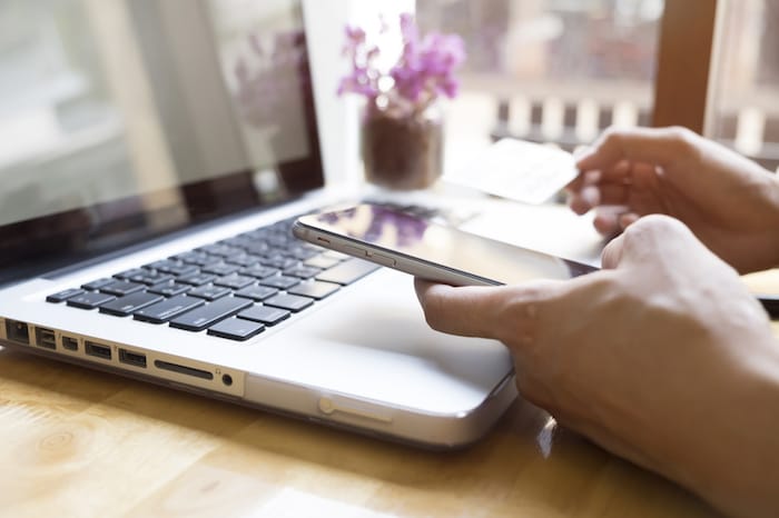 woman on laptop and phone