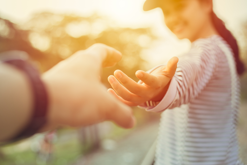 woman reaching hand back to help