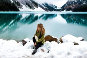 Woman sitting down by a lake thinking about Figure Skating and Eating Disorders